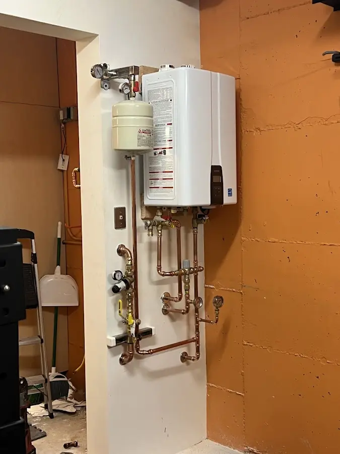 Plumbing technician inspecting water heater connections in Bagdad